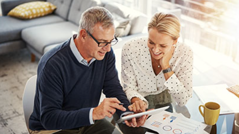 A man is showing a woman content on a tablet
